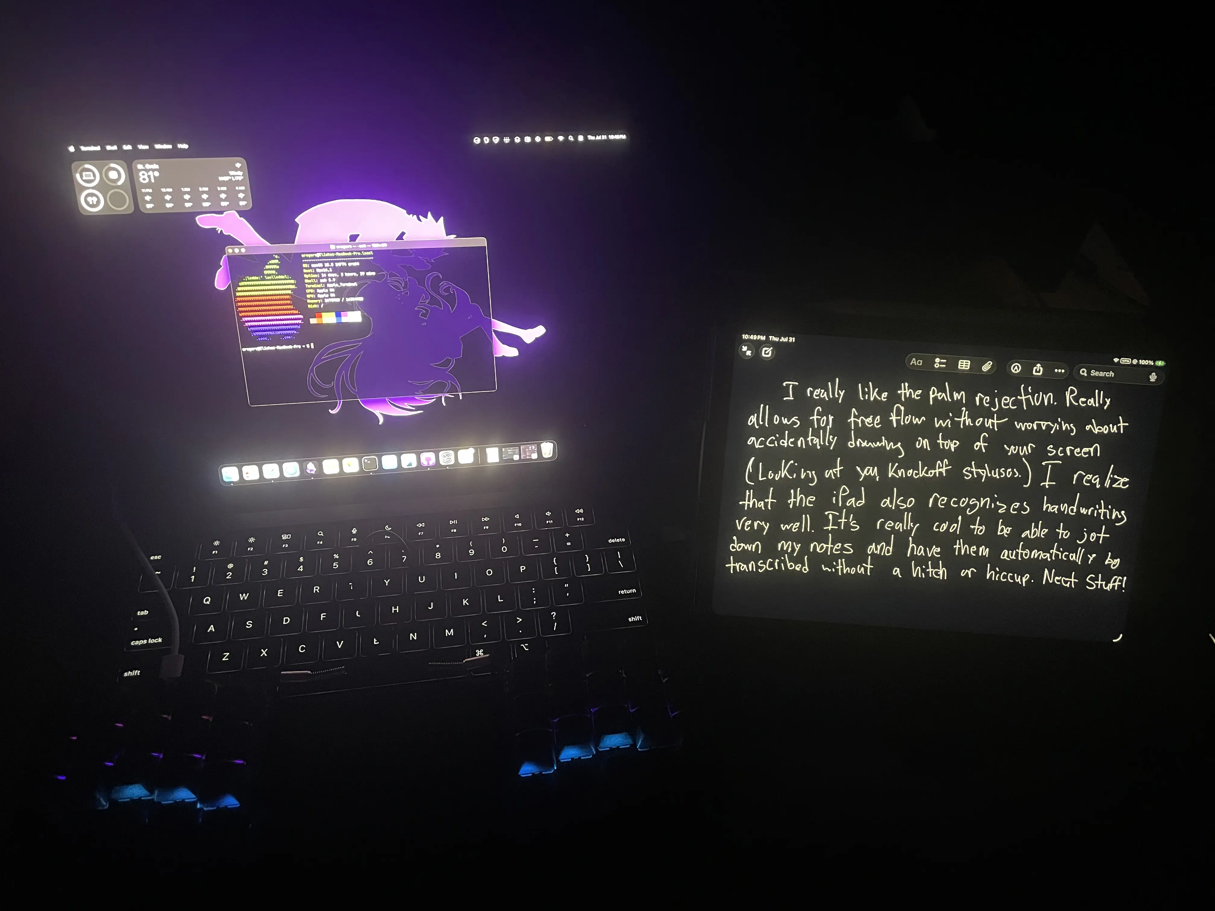 Image of a dark room with an Apple M4 MacBook Pro and 11th generation iPad A16with their screens on showing content and a split mechanical keyboard sitting between the MacBook's trackpad